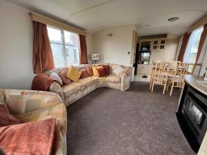 a living room with a couch and a table at Coastal Caravan Holidays - Puffin 14 in Tunstall