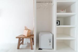 a refrigerator in a room with a wooden table at The Room Padang-Padang in Uluwatu