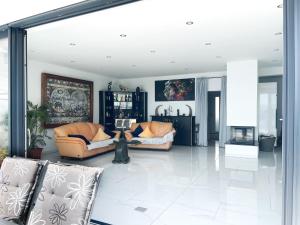 ein Wohnzimmer mit 2 Sofas und einem Kamin in der Unterkunft Villa White Pearl Diamond Haus B, Opatija mit Meerblick & Pool in Opatija