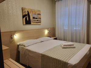 una camera da letto con un letto e due asciugamani di Hotel Dei Fiori a Milano