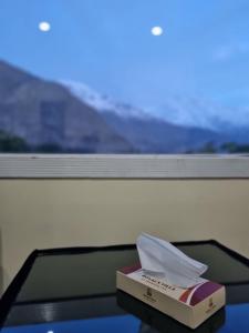 una caja de pañuelos sentada en una mesa junto a una ventana en Royal's Villa by Premiere Inn, Hunza, en Hunza