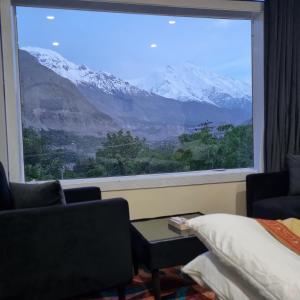 a room with a large window with a view of mountains at Royal's Villa by Premiere Inn, Hunza in Hunza