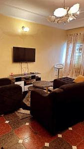 a living room with couches and a flat screen tv at Peaceful home in Yaoundé