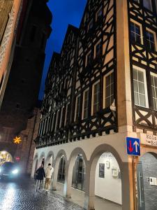 dos personas caminando por una calle al lado de un edificio en Cochemer Arkaden, en Cochem