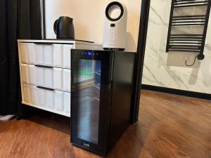 a black refrigerator in a room next to a dresser at The Cottage Hideout in Upholland