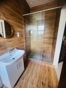 uma casa de banho com um chuveiro e um lavatório. em Sewelo inn guesthouse em Maun