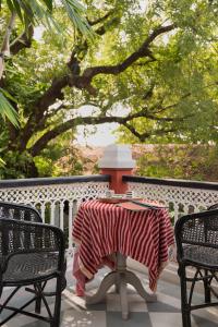 einen Tisch mit einer roten und weißen Decke auf einer Veranda in der Unterkunft Ahilya Fort in Maheshwar