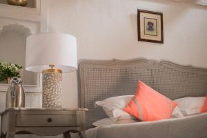 a lamp sitting on a table next to a bed at Ahilya Fort in Maheshwar
