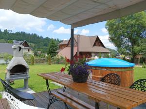 a picnic table with a pizza oven and a grill at Będzie Fajnie in Poronin