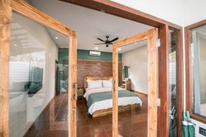 Belukar Villas في غيلي تراوانغان: غرفة نوم بسرير وجدار من الطوب