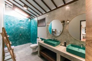 a bathroom with two sinks and a mirror at Belukar Villas in Gili Trawangan