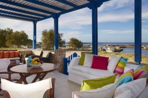 a patio with a white couch and chairs and a table at Alexandros House in Monolithos
