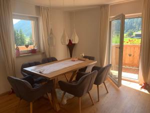 uma sala de jantar com uma mesa de madeira e cadeiras em Herzzeit Apartments em Flachau