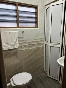 a bathroom with a toilet and a window and a sink at Homestay Hajrah in Ipoh