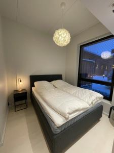 um quarto com uma cama e uma grande janela em Levi Cranberry C1, ski-in ski-out 2 bedroom apartment in Levi center em Levi