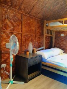 a bedroom with a bunk bed and a fan at JUSH NATIVE AND GLAMPING in Dauis