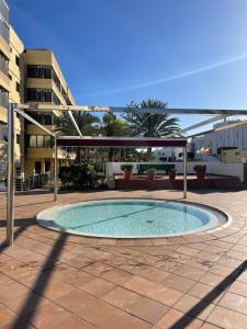 a swimming pool in a courtyard with a building at APTO Exelsior, Yumbo, Dunas y Playa in San Bartolomé de Tirajana
