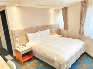 um quarto com uma cama grande e uma mesa de cabeceira com uma cama sidx sidx sidx em 華麗大飯店Ferrary Hotel em Taipei