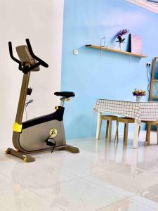 a room with a exercise bike next to a table at Free & Easy Leisure Homestay in Batu Caves