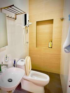 a bathroom with a white toilet and a sink at Free & Easy Leisure Homestay in Batu Caves
