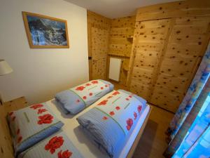 two beds in a room with wooden walls at Appartamenti la Fontana in San Martino in Badia
