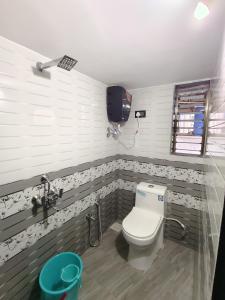 a bathroom with a toilet and a television in it at Bethel House Holiday Stay-inn in Alibaug
