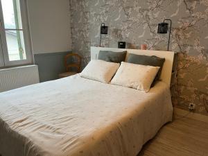 a bedroom with a white bed with two pillows at Chambre d'hôtes de La Clie in Saint-Michel-de-Fronsac