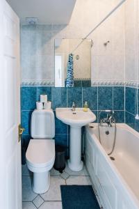 a bathroom with a toilet and a sink and a tub at Apartments are located in the Heart of Shoreditch in London