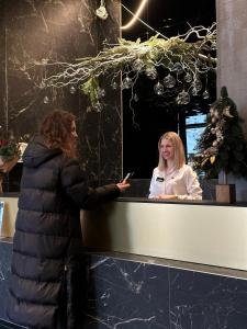 two women standing at a counter looking at their cell phone at Diamond Resort White in Bukovel
