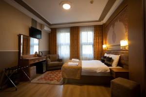 a hotel room with a bed and a desk at Tashkonak Studio Suites in Istanbul