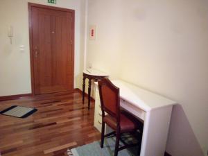Habitación con escritorio y silla junto a una puerta en Costa Lodge Madeira, pick up - drop off, car and motorcycle rentals, en Santa Cruz
