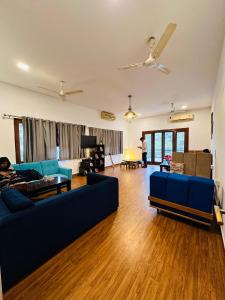 ein Wohnzimmer mit einem blauen Sofa und Holzböden in der Unterkunft A Sleepy Fox Hostel in Neu-Delhi