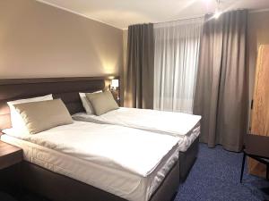 una camera d'albergo con un grande letto con lenzuola bianche di Hotel Boreas a Rovaniemi