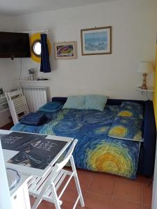 Bett in einem Zimmer mit einem Tisch und einem Bett in der Unterkunft Felciaio in Capoliveri