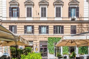 ローマにあるRome sweet homeの黒いシャッター付きの窓と傘が備わる大きな建物