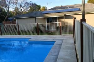 ein blauer Pool vor einem Haus in der Unterkunft New and Cozy 2 Bedrooms Granny Flat with Aircon & Pool in Baulkham Hills