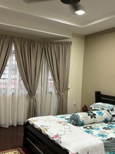 um quarto com uma cama grande e cortinas em Homestay Hajrah em Ipoh