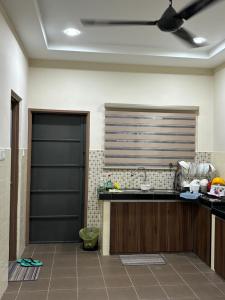 a kitchen with a counter and a ceiling fan at Homestay Hajrah in Ipoh