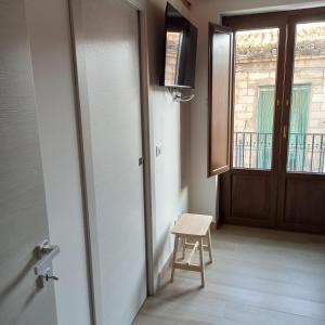 a room with a door and a stool and a window at Dream House Castellana in Castellana Sicula