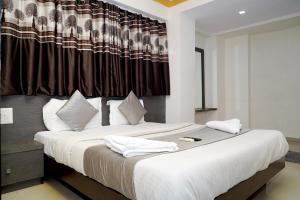 a bedroom with a large bed with white pillows at Balaji Hotel in Ahmedabad