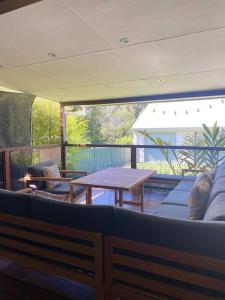 a living room with a table and a blue couch at OAK FLATS - Cosy Getaway in Lake Illawarra