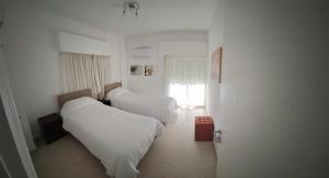 a hotel room with three beds and a window at Cozy 2 Bdr Nicosia City Free Parking Wifi in Nicosia