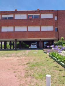 een gebouw met een auto geparkeerd op een parkeerplaats bij Apartamento Alberobello in Punta del Este