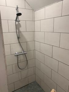 een douche met een slang in een wit betegelde badkamer bij Loft au calme, idéal pour famille, proche de Reims in Saint-Brice-et-Courcelles