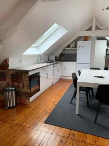a kitchen with white cabinets and a table with chairs at Loft au calme, idéal pour famille, proche de Reims in Saint-Brice-et-Courcelles +7 photos