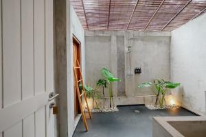 a room with potted plants in a room with a ceiling at The Room Padang-Padang in Uluwatu