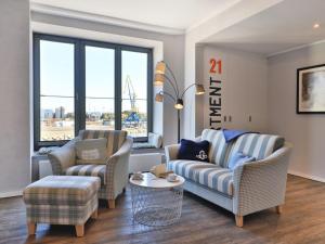 ein Wohnzimmer mit zwei Stühlen und einer Couch und einem Tisch in der Unterkunft Ohlerich Speicher App. 21 in Wismar