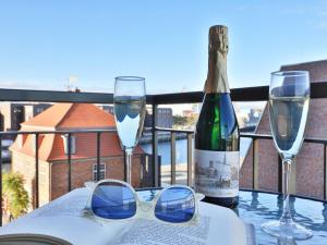 einen Tisch mit Gläsern, eine Flasche Wein und ein Buch in der Unterkunft Ohlerich Speicher App. 21 in Wismar