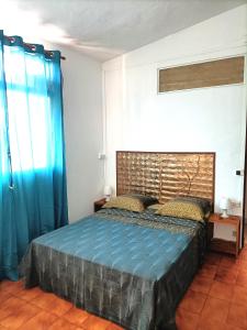 a bedroom with a bed with blue sheets and blue curtains at Locamarre G GONDET in Sainte-Anne