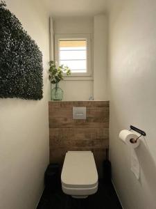 a bathroom with a white toilet and a window at Douceur champenoise in Dizy